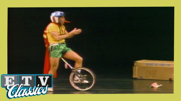 Man on stage riding a unicycle